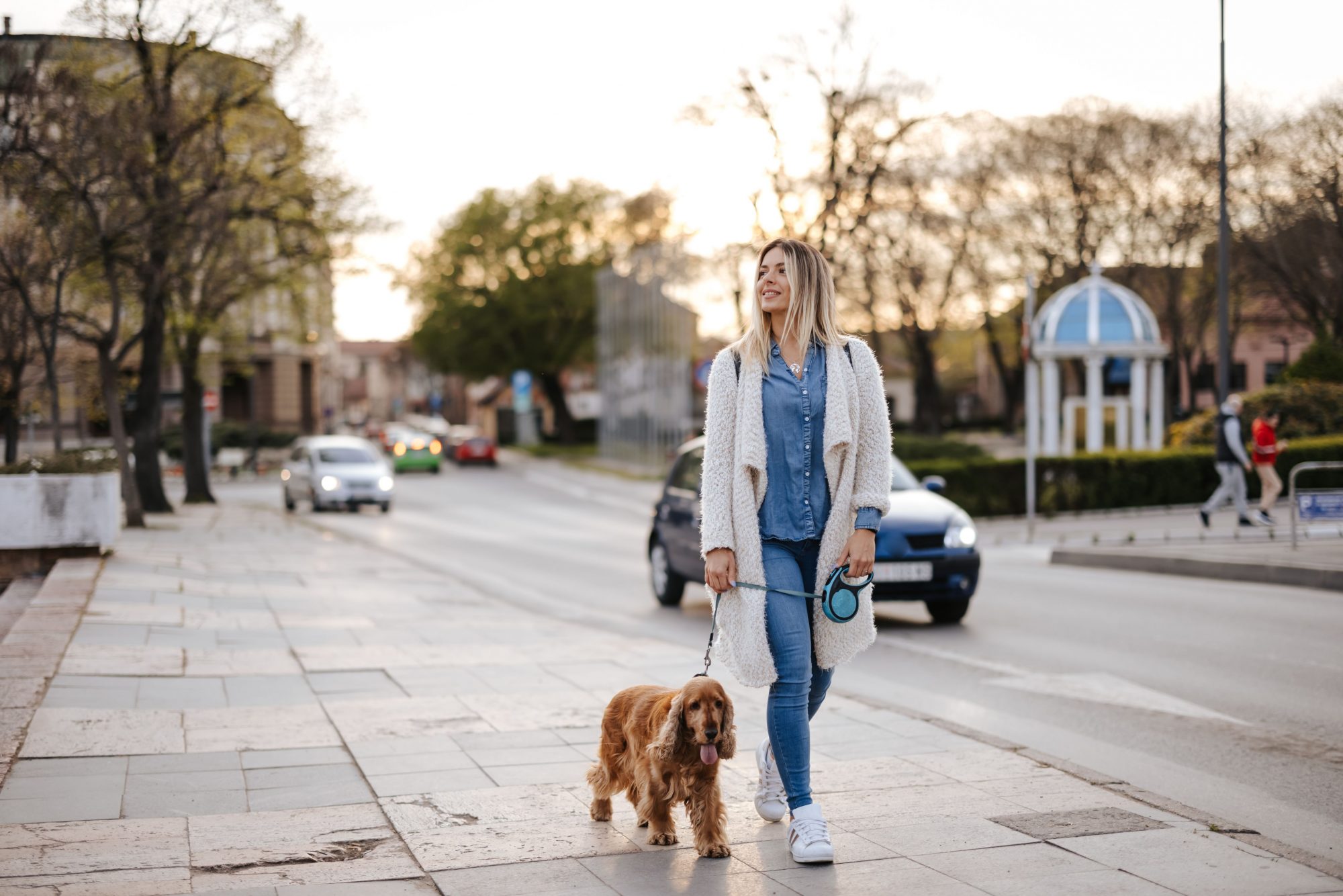 Woman in the city walking her dog.